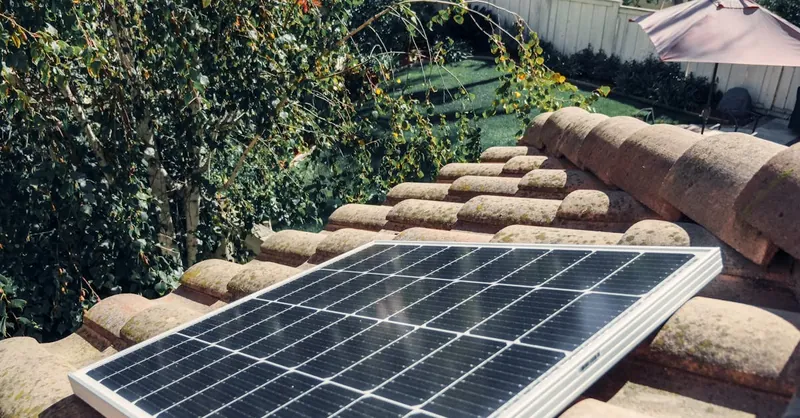 Close-up of a solar panel installed on a tiled roof, capturing clean energy.