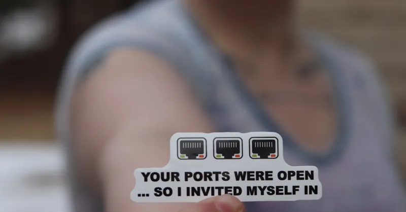 Person holding a funny internet security sticker about open ports.